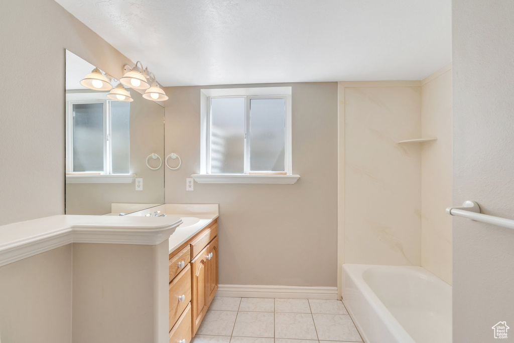 Full bathroom with tile patterned floors, vanity, and baseboards