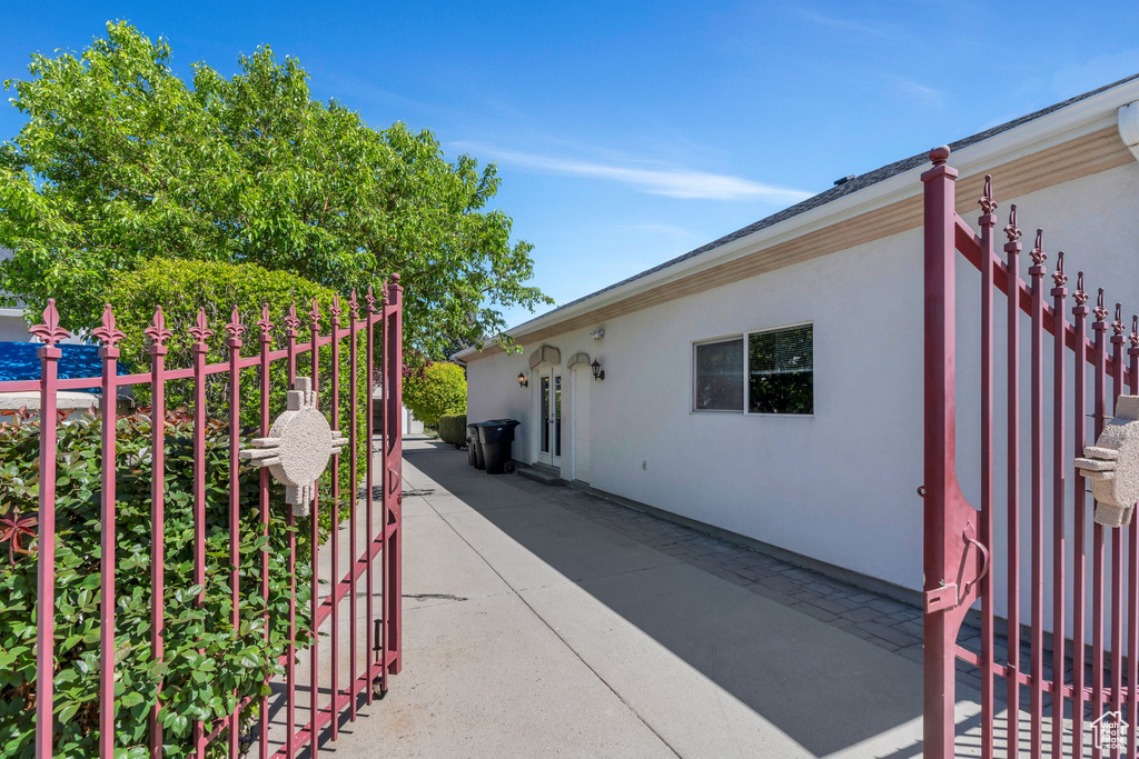 View of side of property with stucco siding, a patio, and fence