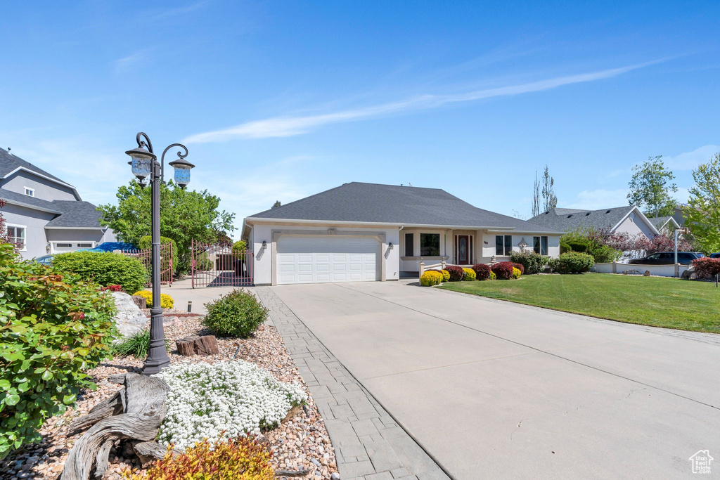 Ranch-style home featuring an attached garage, driveway, and stucco siding