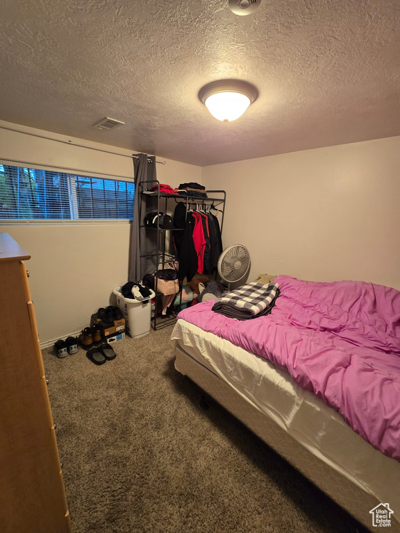 Carpeted bedroom with a textured ceiling