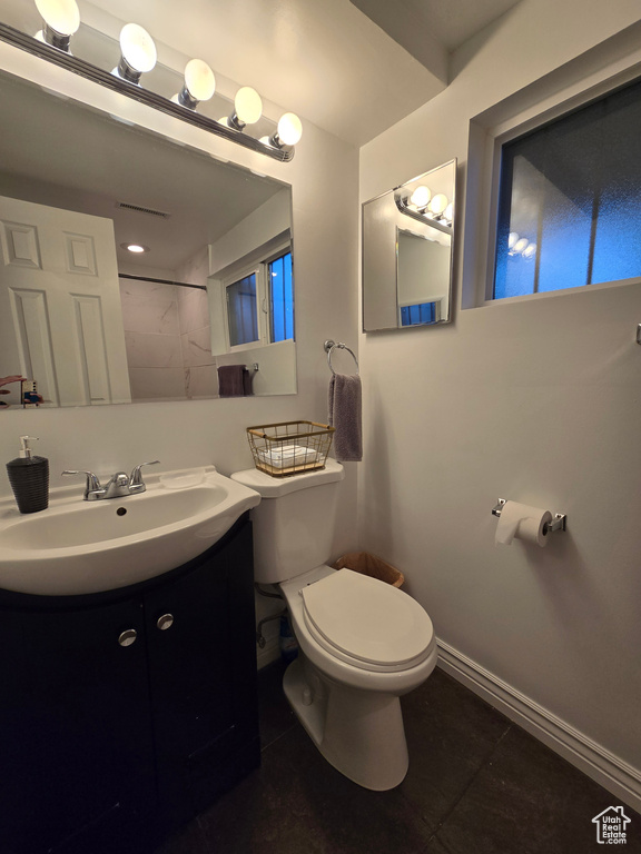 Bathroom with toilet, tile patterned flooring, vanity, and baseboards