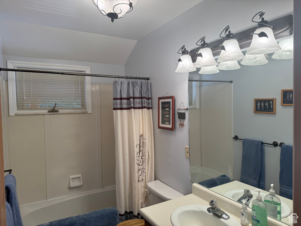 Full bathroom featuring lofted ceiling, vanity, shower / bath combo, and toilet