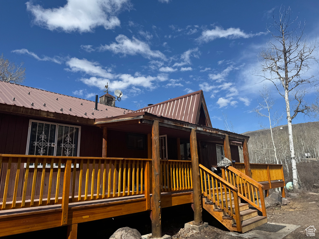 Back of property featuring metal roof and a wooden deck