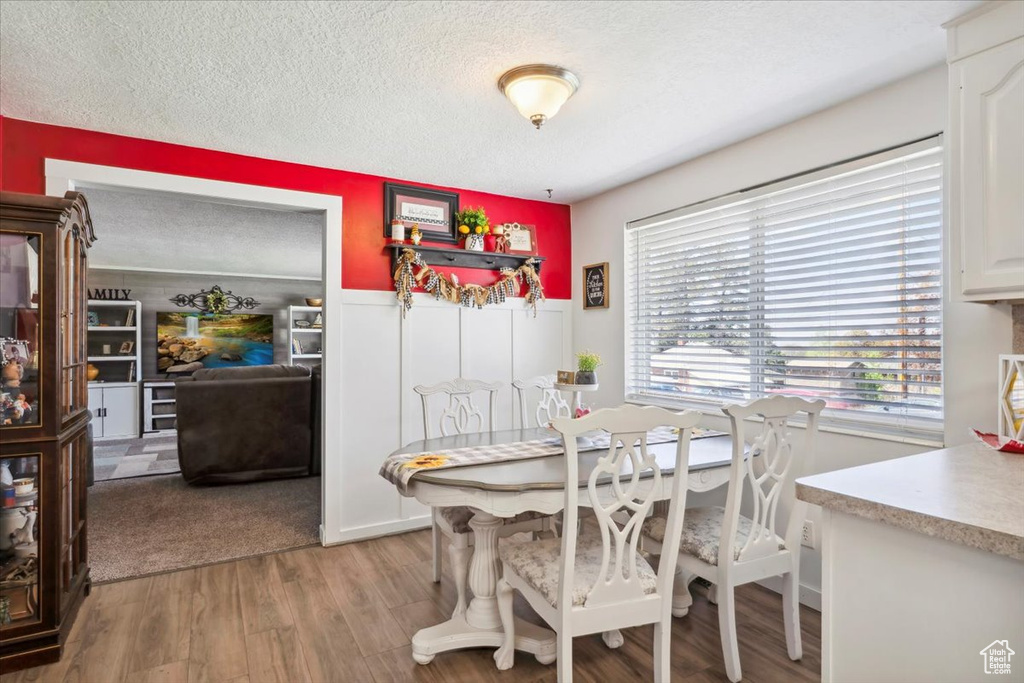 Dining space with a textured ceiling and light wood-style floors