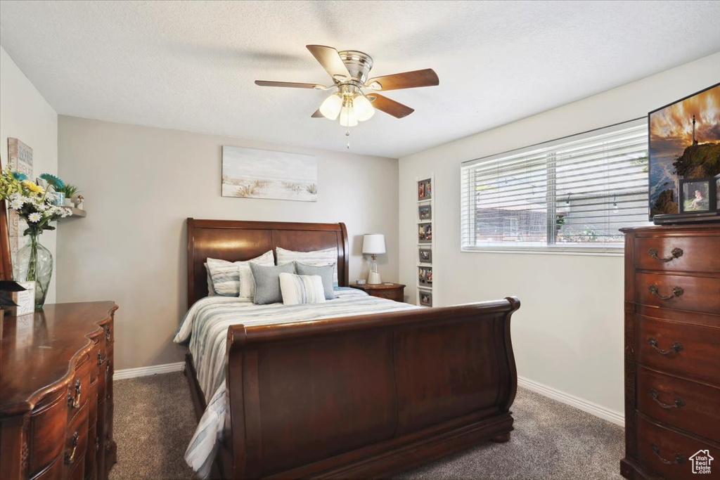 Carpeted bedroom with baseboards and ceiling fan