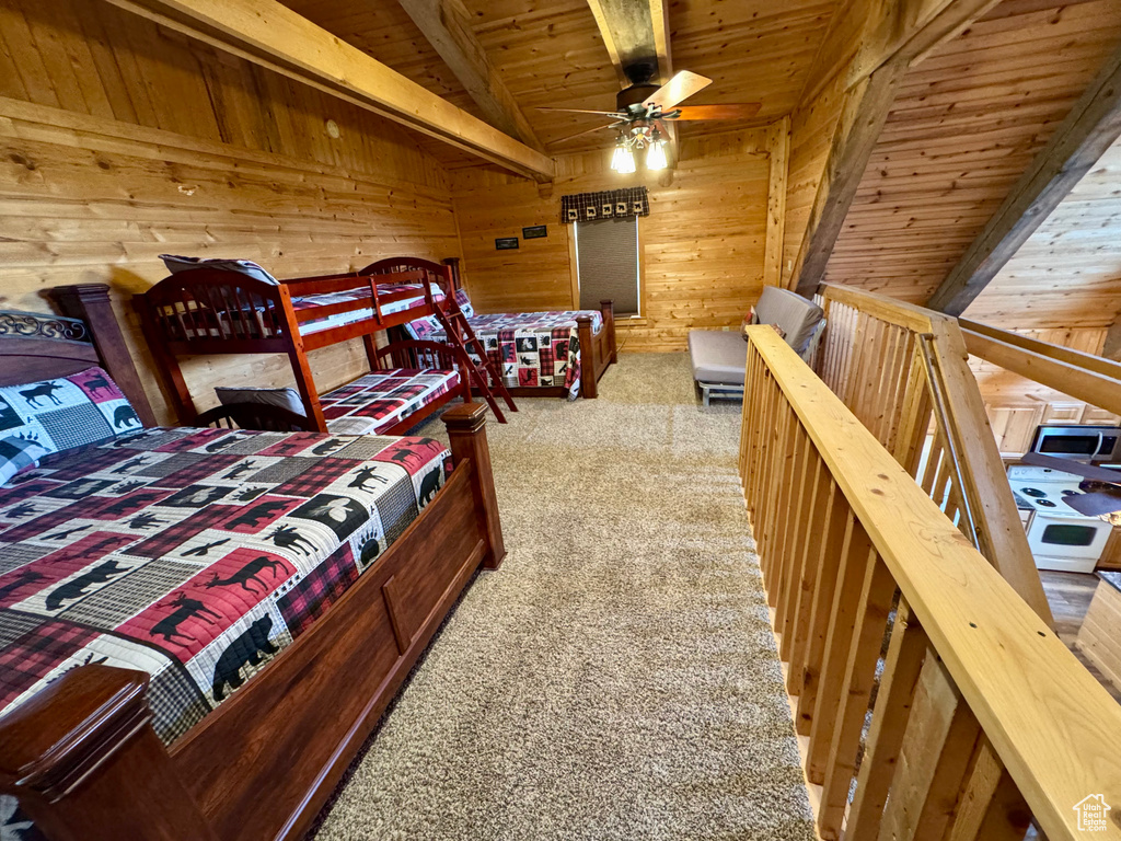 Carpeted bedroom featuring wooden walls and wood ceiling
