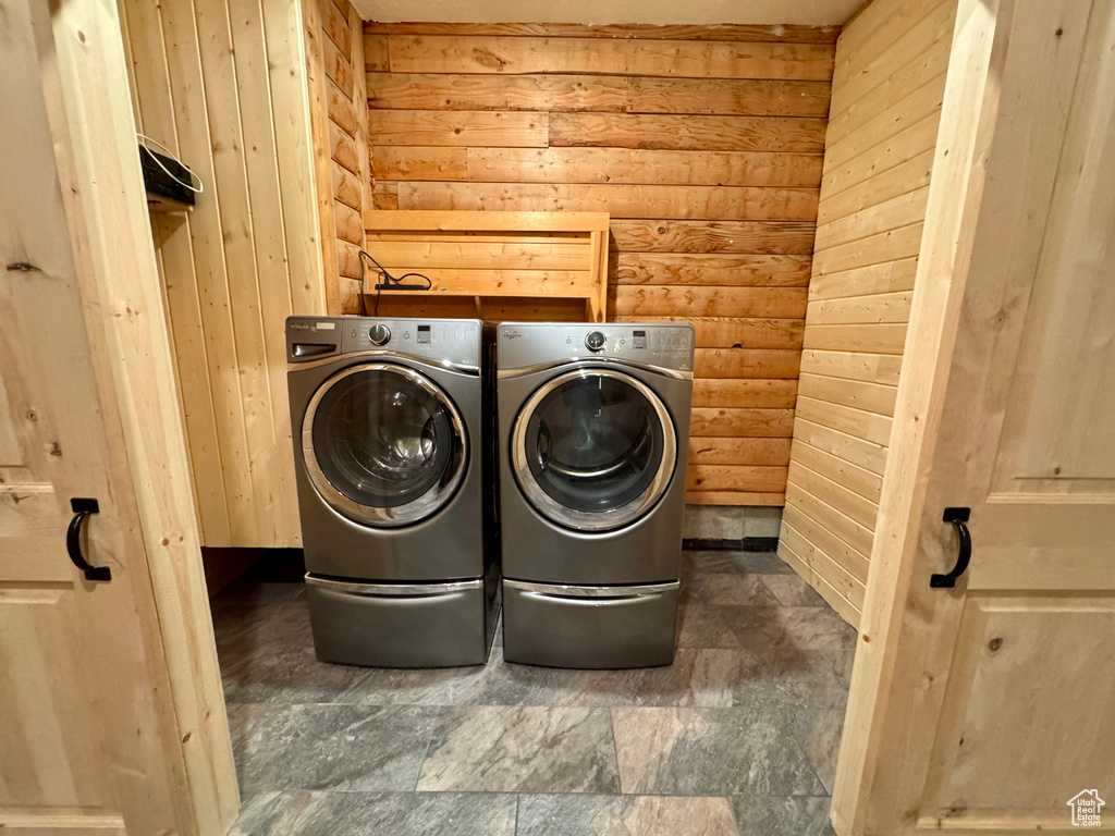 Washroom with washing machine and dryer and wooden walls