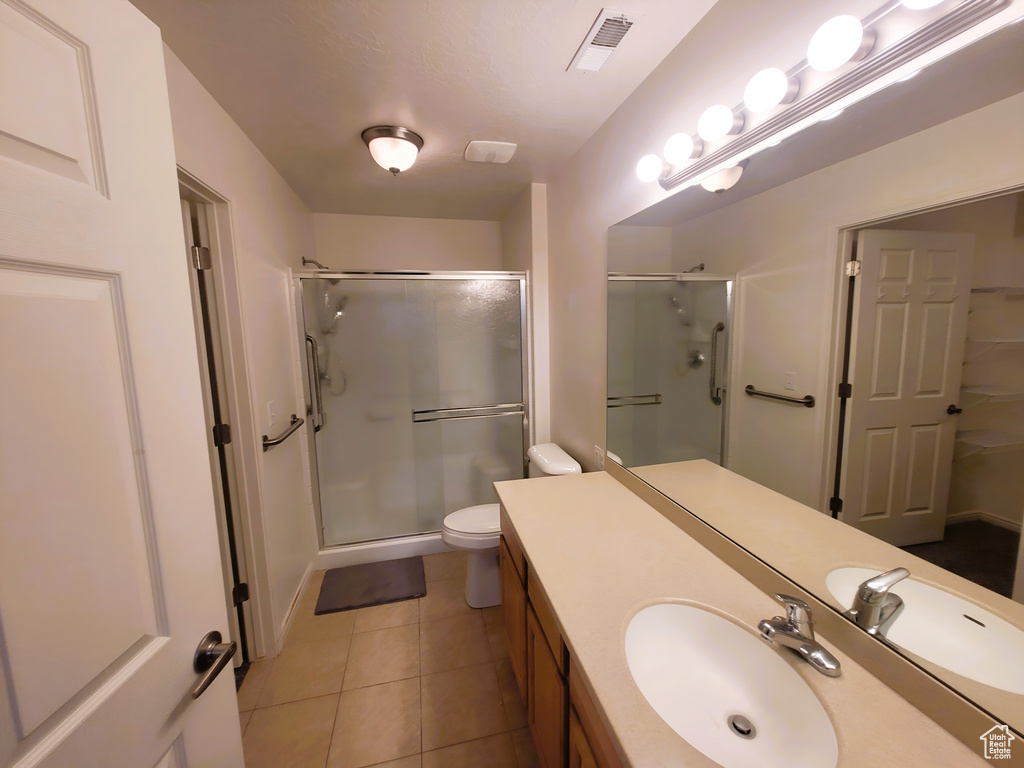 Bathroom featuring vanity, a shower stall, visible vents, and tile patterned floors