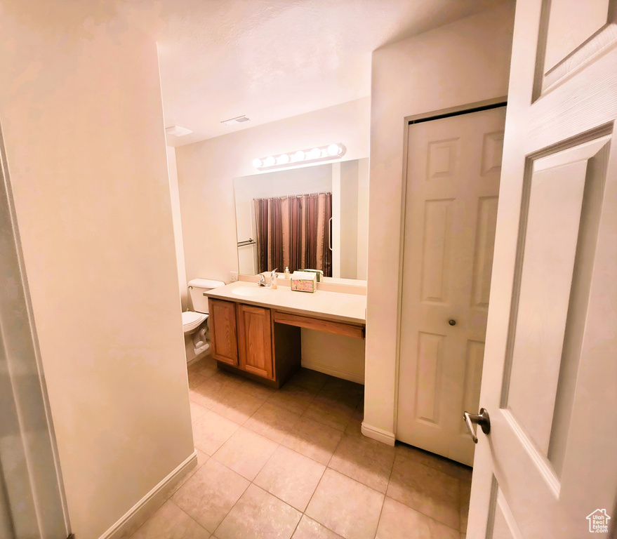 Bathroom with baseboards, tile patterned flooring, vanity, and visible vents