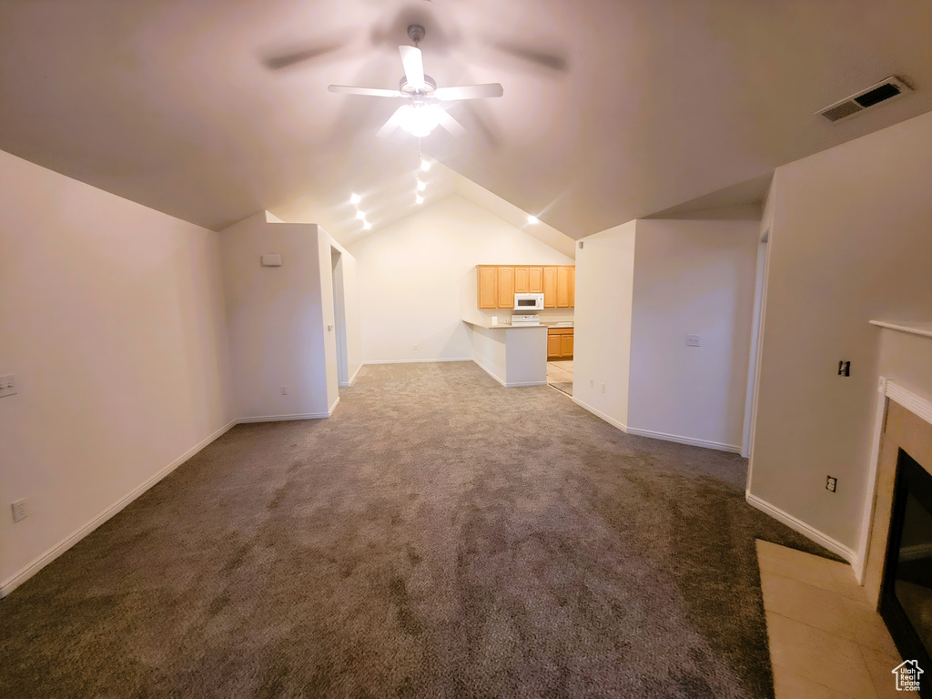 Additional living space featuring carpet flooring, visible vents, baseboards, ceiling fan, and lofted ceiling
