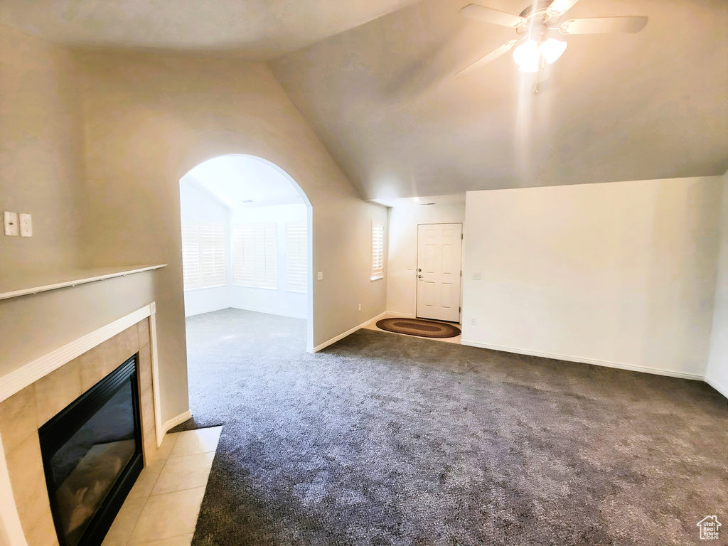 Bonus room with vaulted ceiling, ceiling fan, light colored carpet, a fireplace, and baseboards