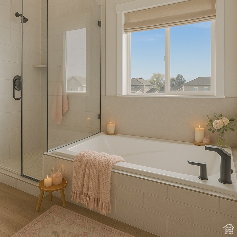 Bathroom with a garden tub, tiled shower, and wood finished floors