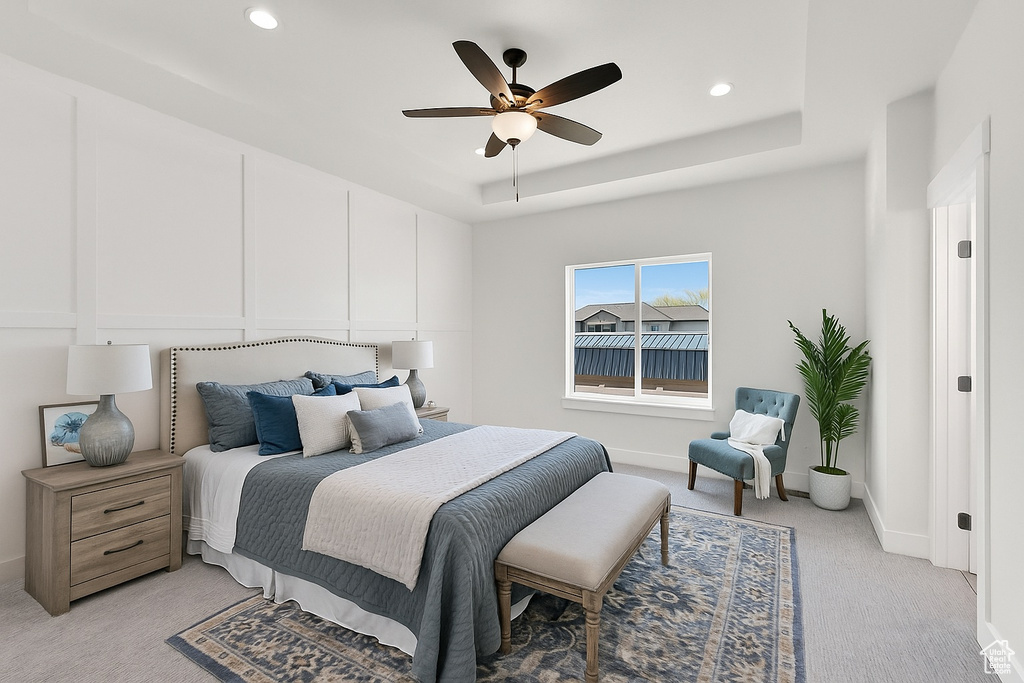 Bedroom featuring light colored carpet, recessed lighting, a ceiling fan, and a raised ceiling
