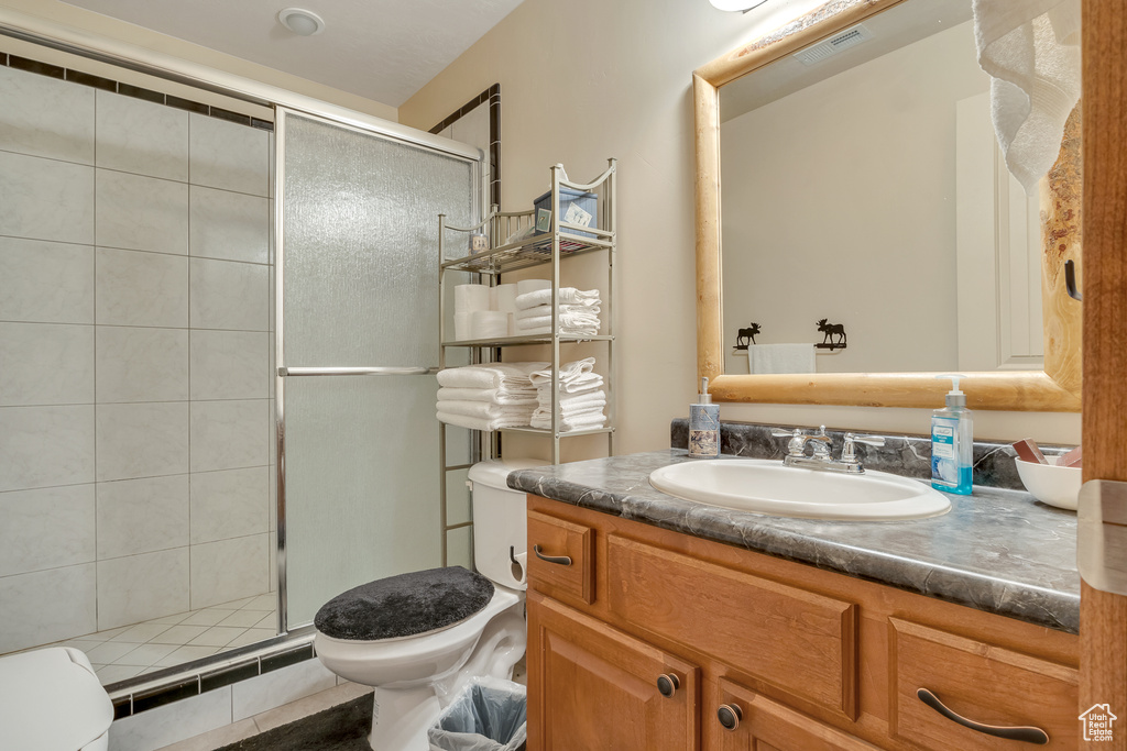 Bathroom featuring toilet, a stall shower, and vanity