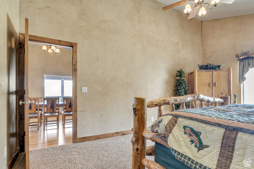 Carpeted bedroom with baseboards and a chandelier