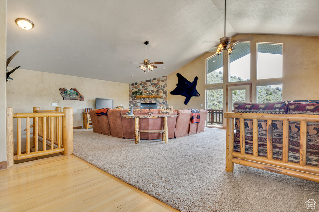 Living area featuring a ceiling fan, wood finished floors, and high vaulted ceiling