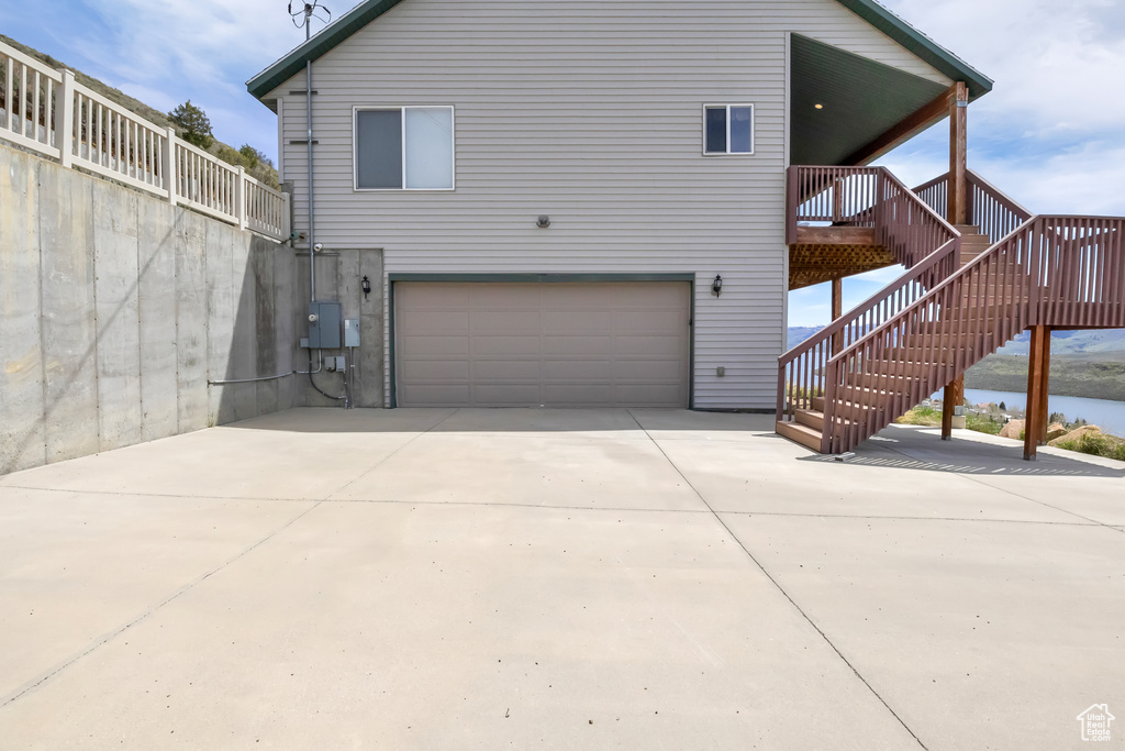 Back of house featuring an attached garage and driveway