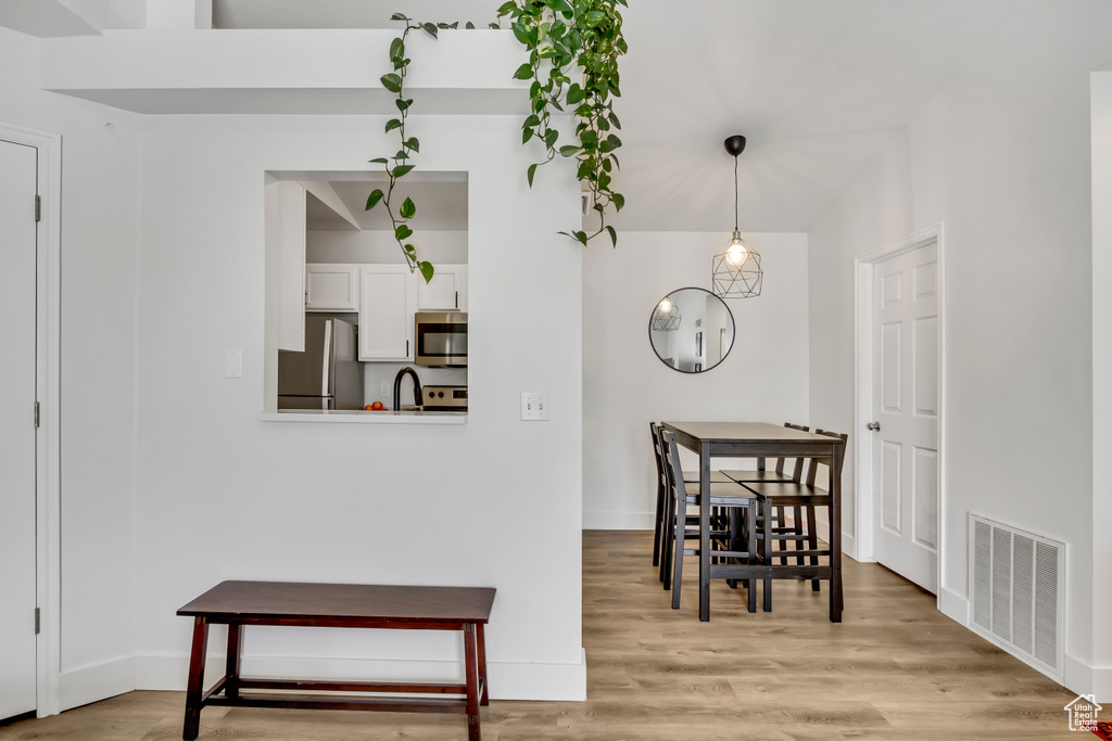 Dining area featuring light wood-style floors and baseboards