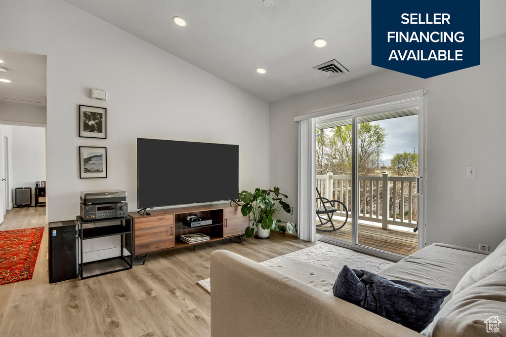Living area featuring lofted ceiling, wood finished floors, and recessed lighting