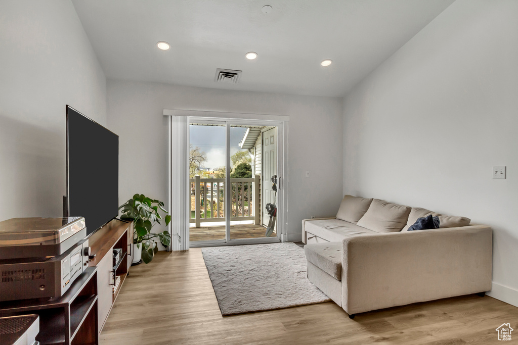 Living area with light wood-style flooring, recessed lighting, and baseboards