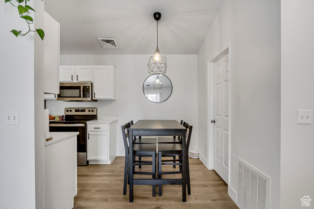 Dining space with light wood-style floors and baseboards