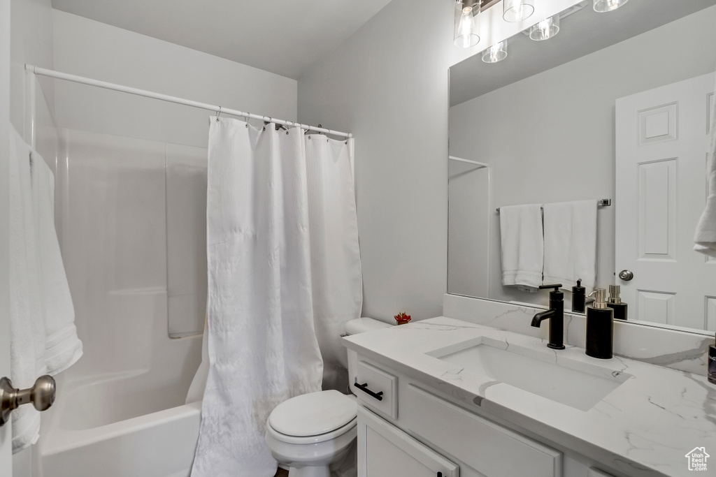 Full bathroom with toilet, vanity, and shower / bathtub combination with curtain