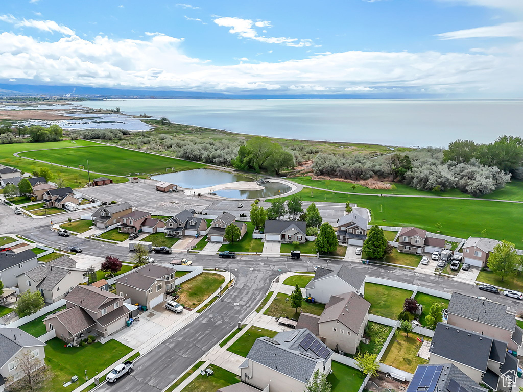 Aerial view of residential area featuring a nearby body of water and a golf club