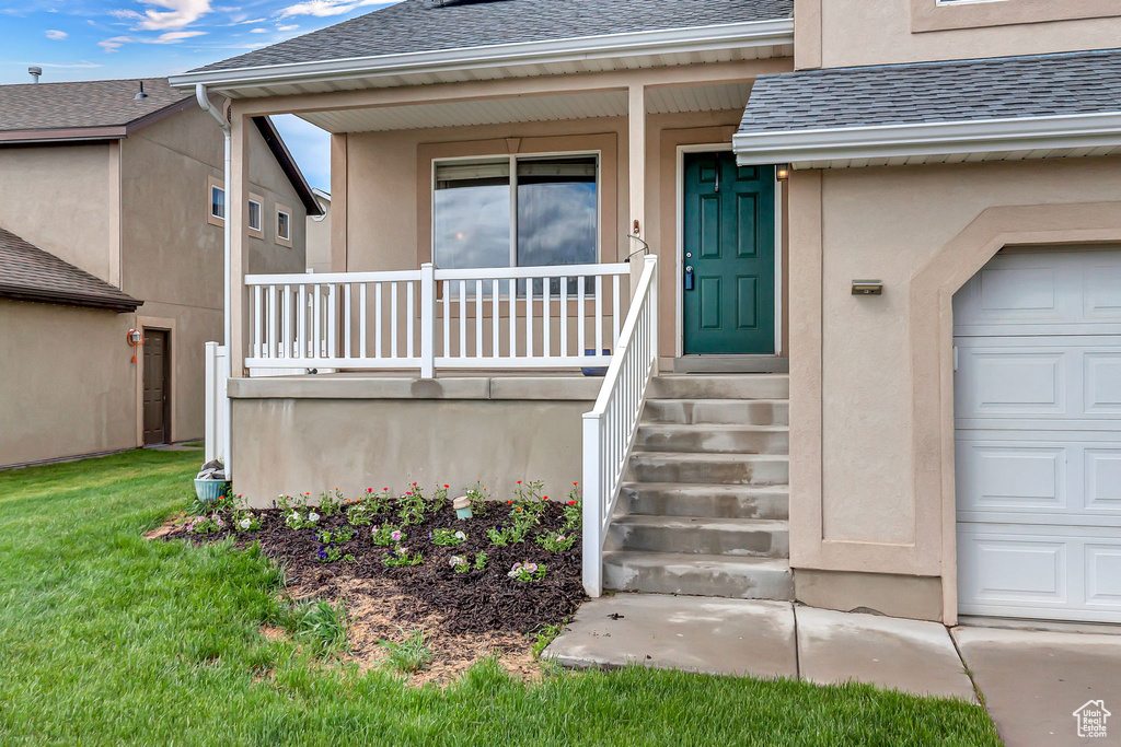 Doorway to property with a porch, roof with shingles, stucco siding, and a garage