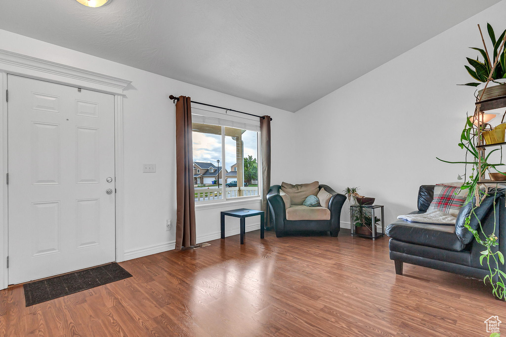 Entryway featuring wood finished floors, lofted ceiling, and baseboards