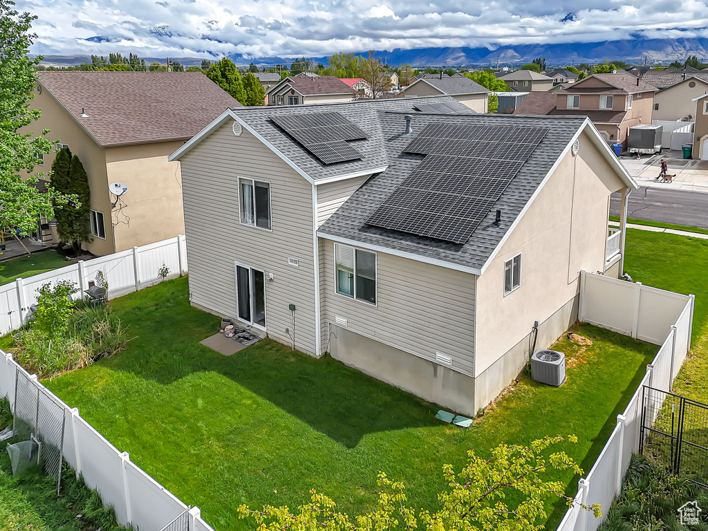 Back of property with roof with shingles, a residential view, roof mounted solar panels, and central air condition unit