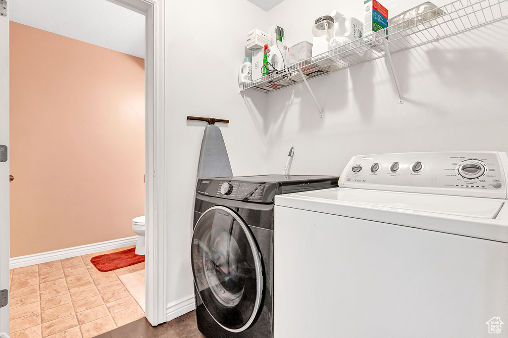 Washroom featuring separate washer and dryer and baseboards