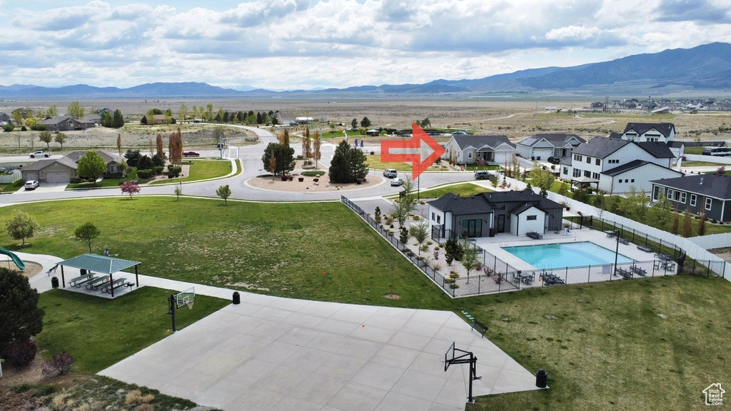Aerial view of residential area featuring a mountainous background and a pool