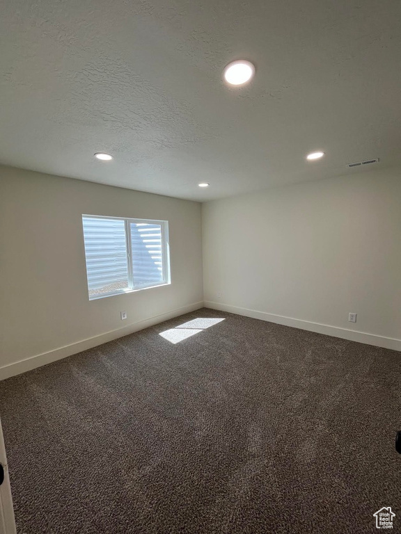 Carpeted spare room with baseboards, recessed lighting, and a textured ceiling