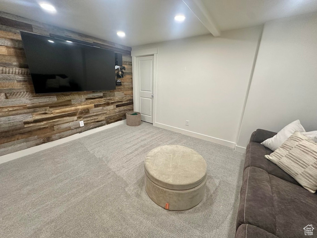 Carpeted living room featuring recessed lighting, wood walls, and baseboards