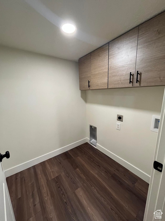 Washroom featuring hookup for an electric dryer, cabinet space, baseboards, dark wood-type flooring, and hookup for a washing machine