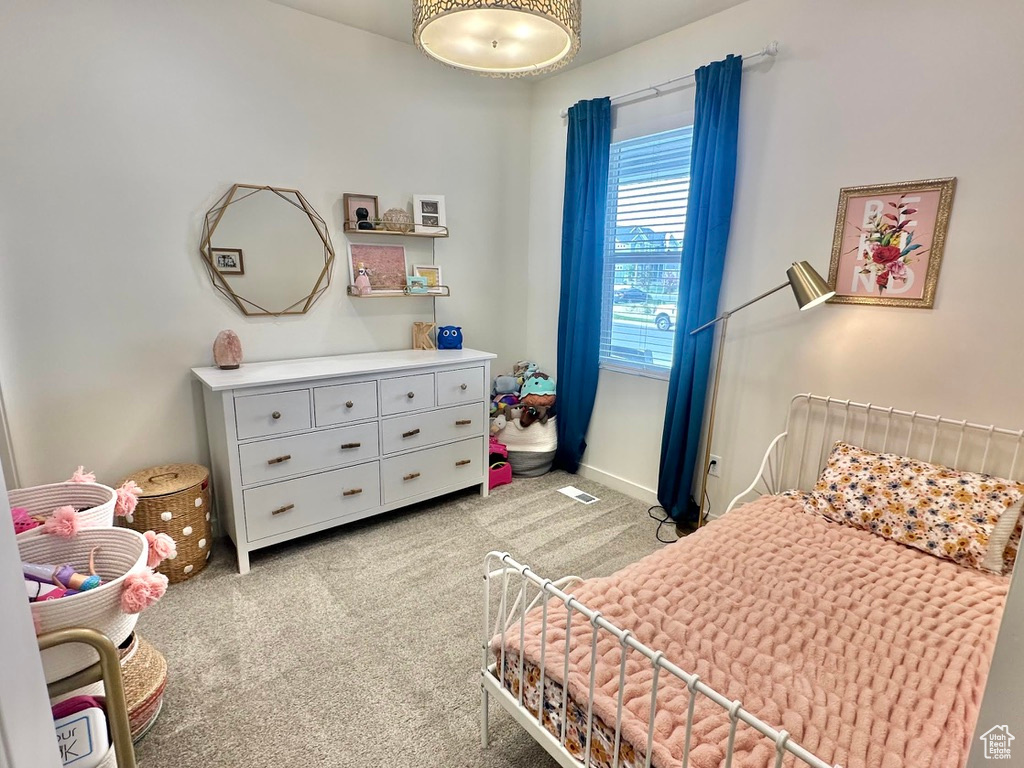 Bedroom featuring light carpet and baseboards