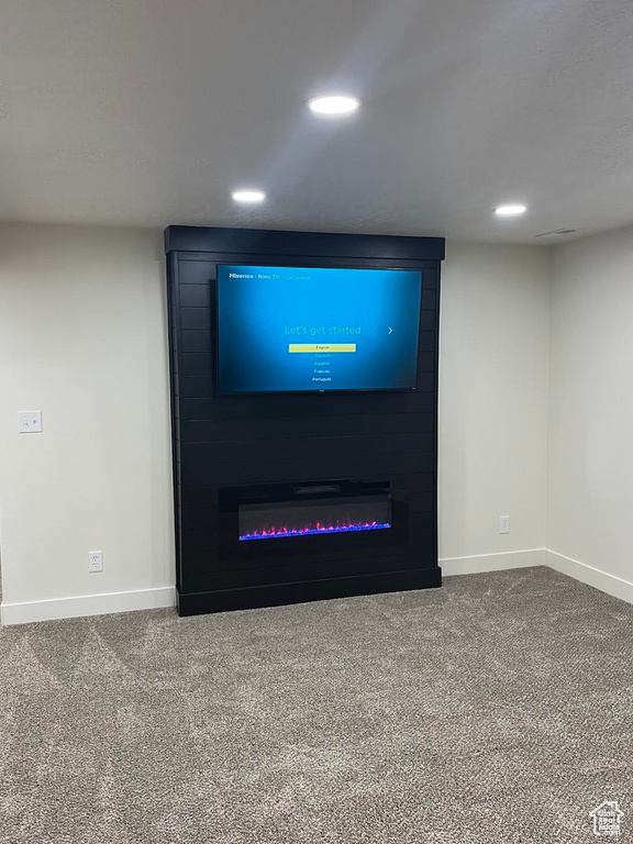 Detailed view of baseboards, carpet floors, recessed lighting, and a fireplace