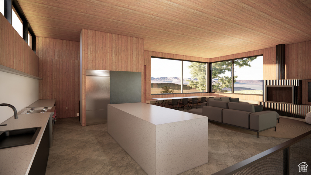 Kitchen with modern cabinets, wood walls, wood ceiling, light countertops, and a sink