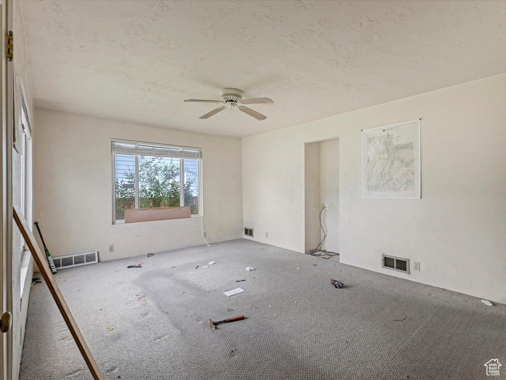 Carpeted spare room featuring ceiling fan