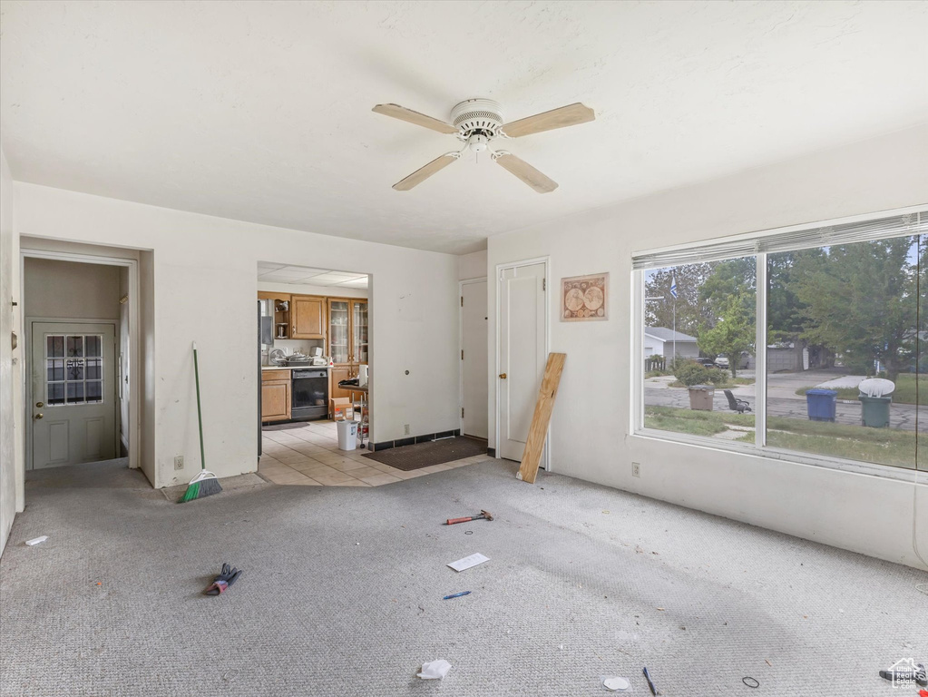 Unfurnished living room featuring light colored carpet and a ceiling fan