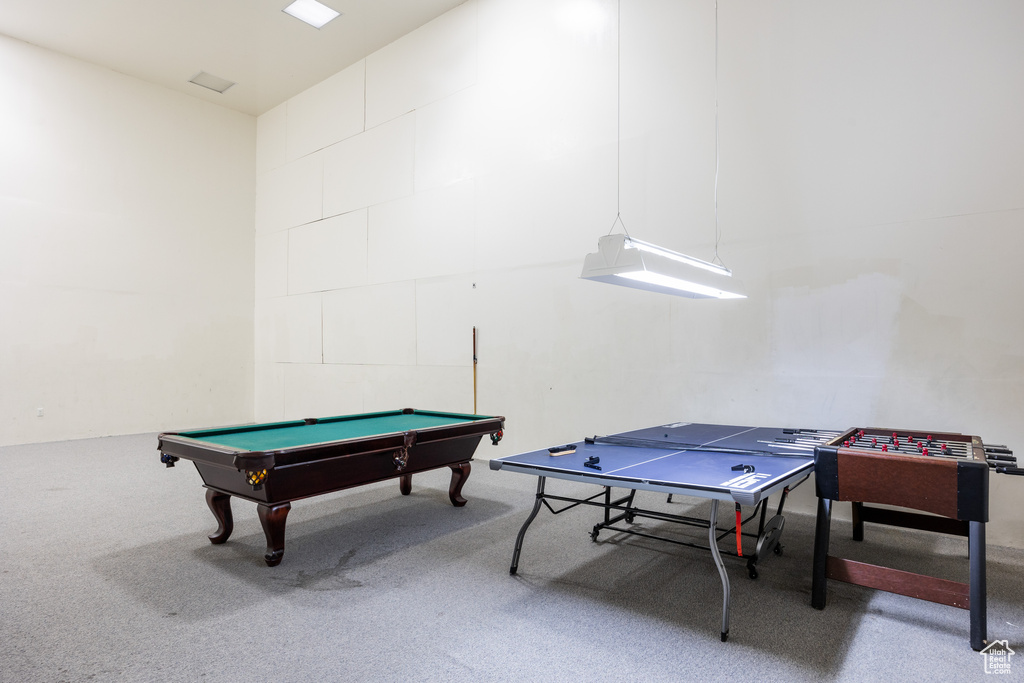 Rec room with carpet floors, pool table, and concrete block wall