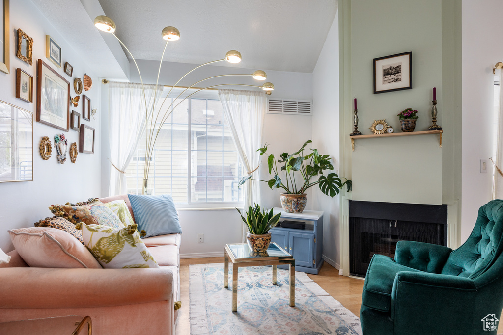 Living room with light wood-style floors, a fireplace, and baseboards