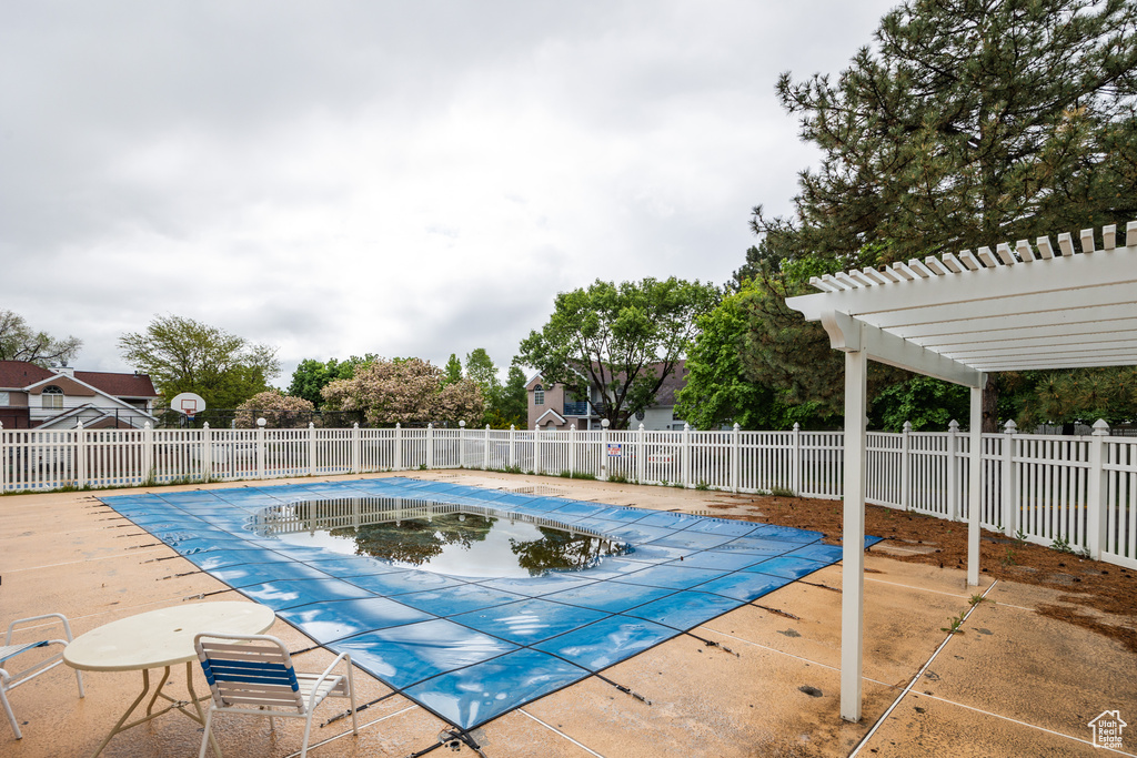 Community pool with fence, a pergola, and a patio area