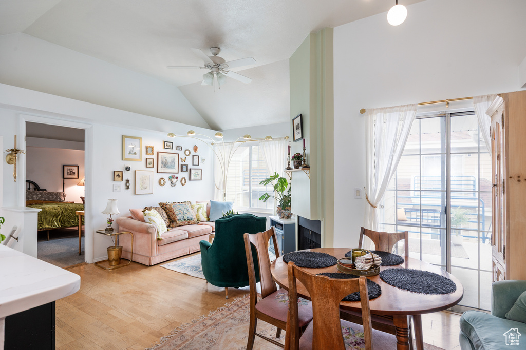 Dining space featuring lofted ceiling, a ceiling fan, light wood-type flooring, and healthy amount of natural light