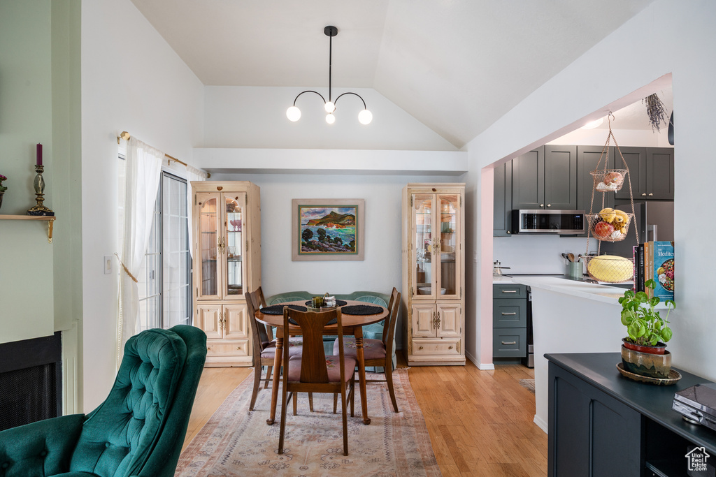 Dining room featuring lofted ceiling, light wood-style flooring, and a chandelier