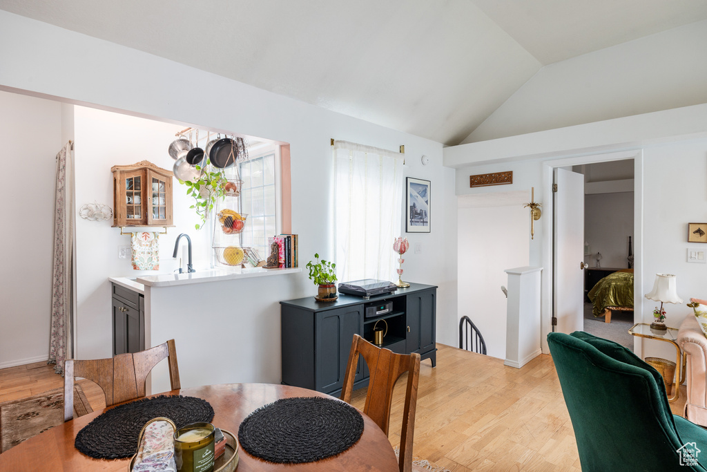 Dining room featuring light wood-type flooring and lofted ceiling