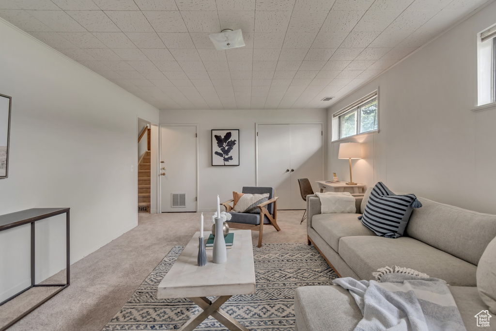 Carpeted living room featuring stairway