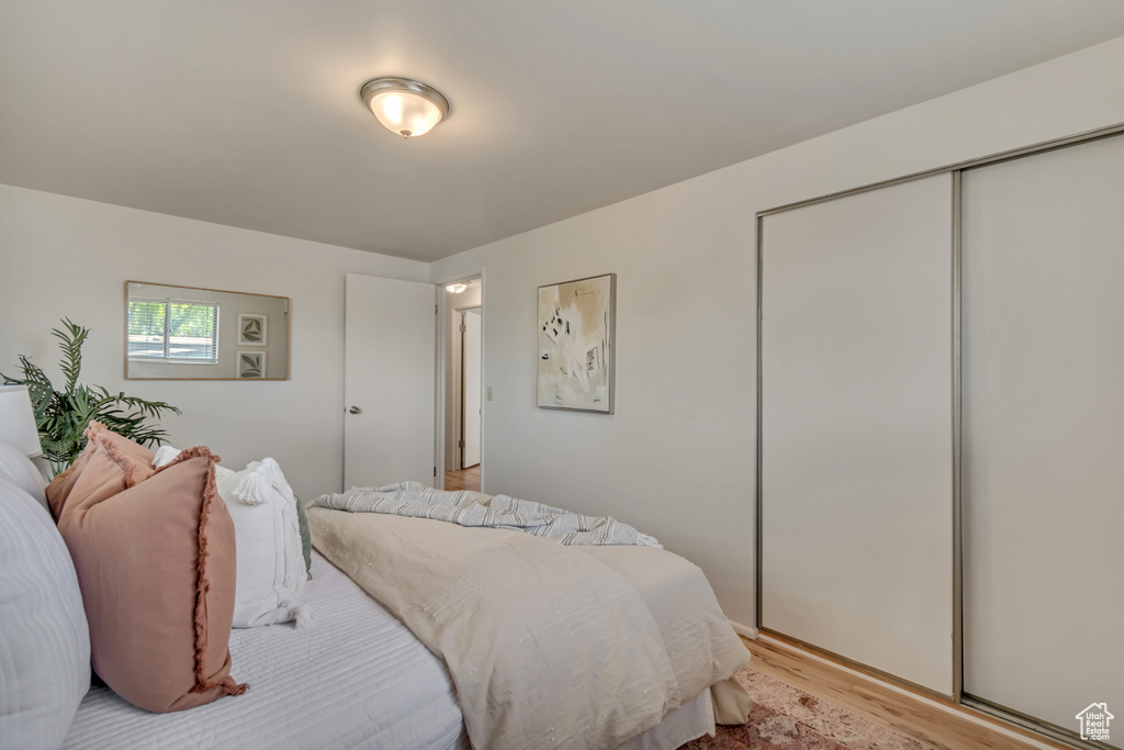 Bedroom with light wood-type flooring and a closet