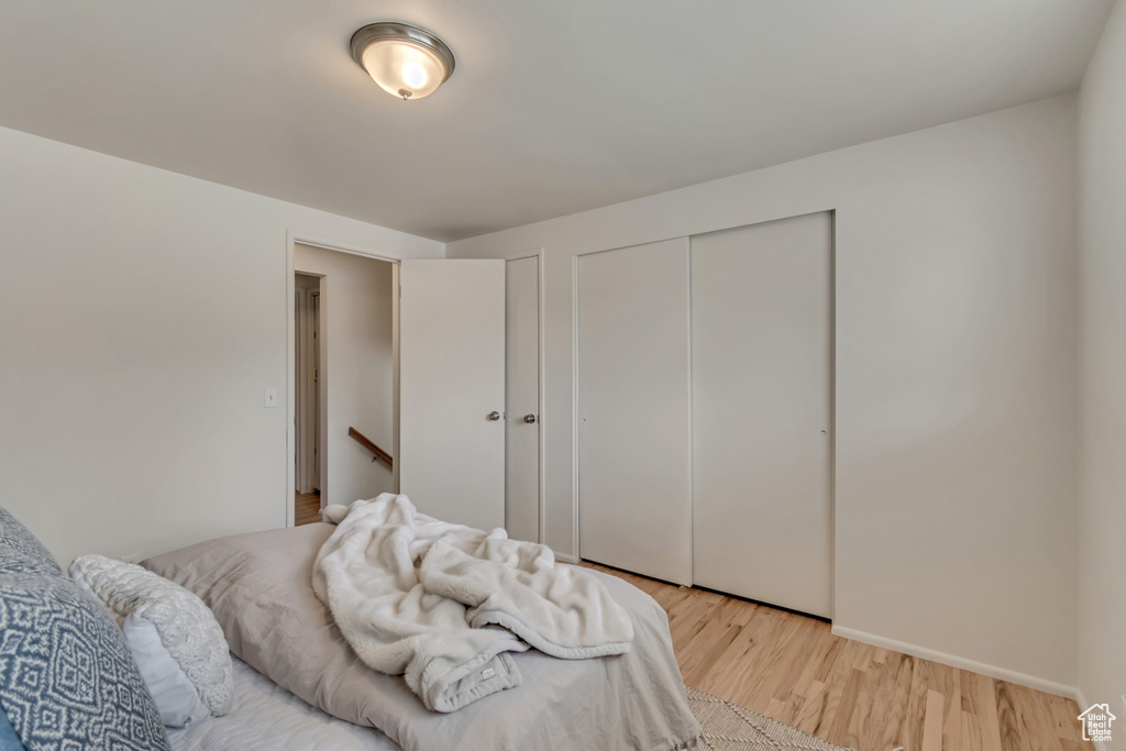Bedroom featuring light wood-style flooring, a closet, and baseboards