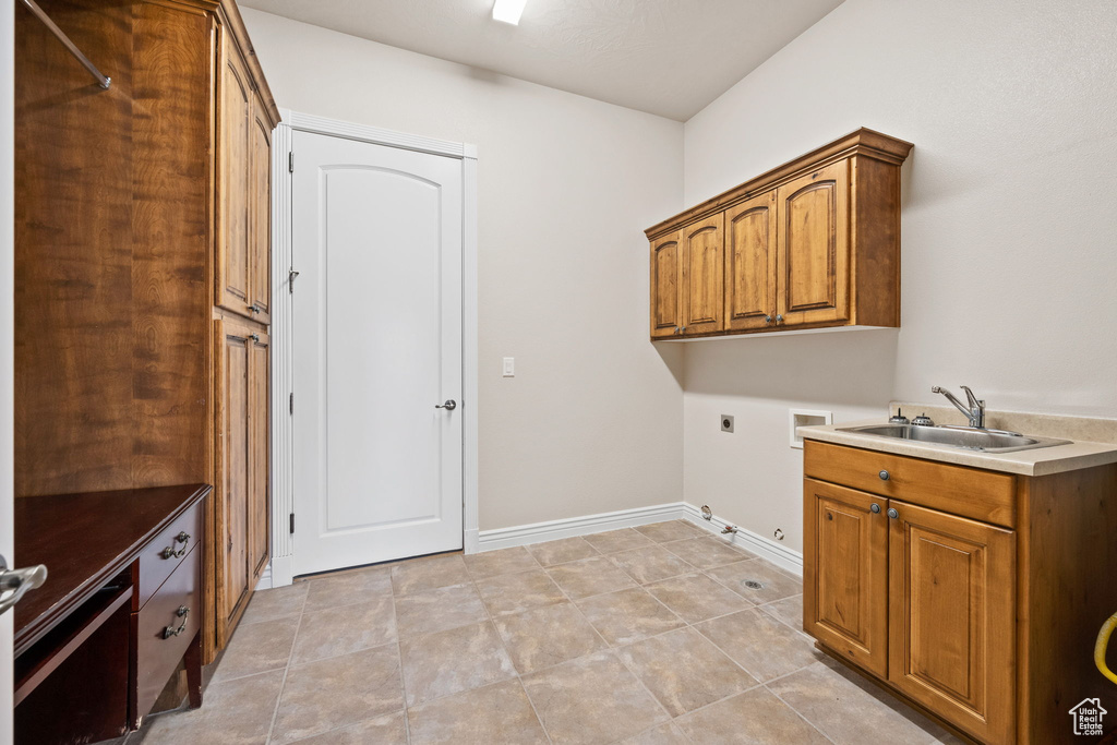 Laundry room featuring electric dryer hookup, gas dryer hookup, hookup for a washing machine, cabinet space, and baseboards